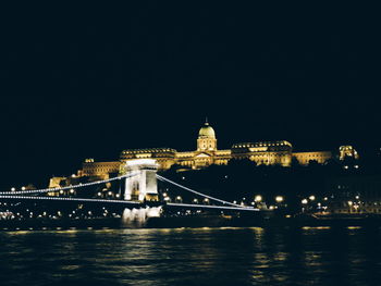 Suspension bridge over river at dusk