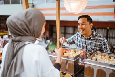 Rear view of woman holding food at restaurant