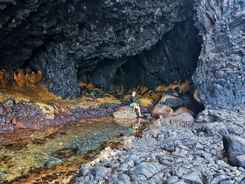 Rear view of man walking on rock
