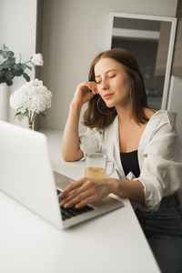 Young businesswoman using laptop at office