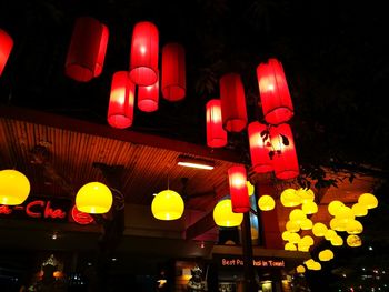 Low angle view of illuminated lanterns hanging at night