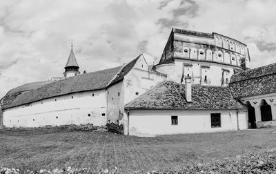 Exterior of old house on field against sky