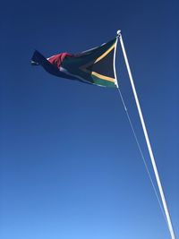 Low angle view of african flag against clear blue sky