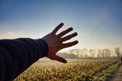 Midsection of person on field against sky