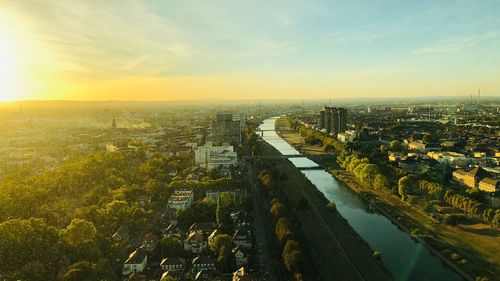 High angle view of river amidst buildings in city at sunset