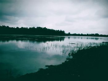 Scenic view of lake against cloudy sky