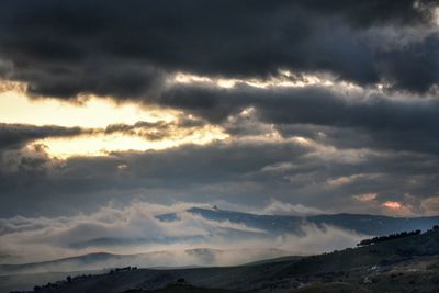 Scenic view of mountains against cloudy sky