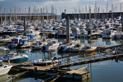 Sailboats moored at harbor against clear sky