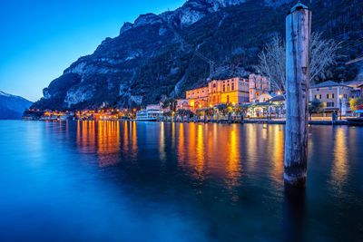 Illuminated waterfront  buildings by lake garda at dusk