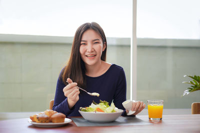 Portrait of young woman eating food