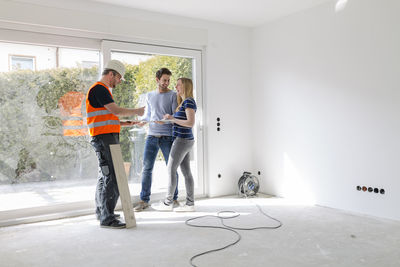 Construction worker explaining couple the construction plan