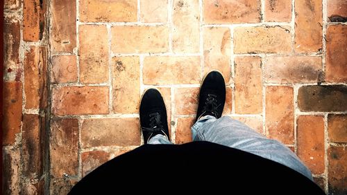 Low section of man standing on tiled floor