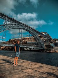 Man standing on bridge against sky