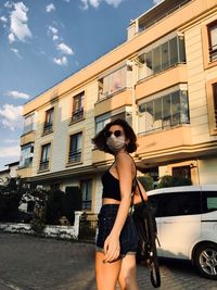 Full length of woman standing against car