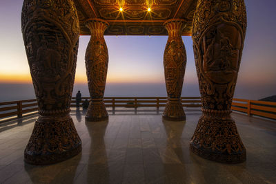Railing by sea against clear sky during sunset