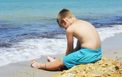 Midsection of shirtless man at beach