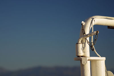 Close-up of white metallic pipe against clear blue sky