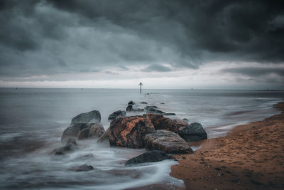 Rocks on beach against sky