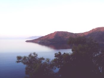 Scenic view of sea and mountains against clear sky