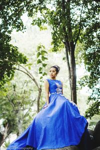 Woman standing by tree against plants