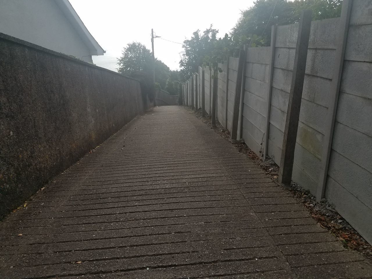 EMPTY FOOTPATH AMIDST BUILDINGS