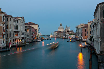 Light trails on grand canal amidst buildings in city