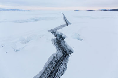 Aerial view of snow covered land against sky