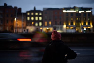 Rear view of man on illuminated street at night