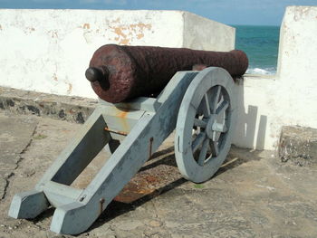 Old rusty cannon by surrounding wall at fortress