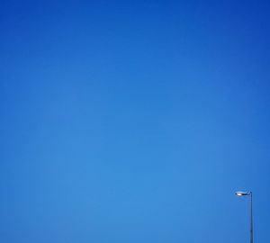 Low angle view of street light against clear blue sky