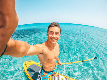 Portrait of smiling man in sea against sky