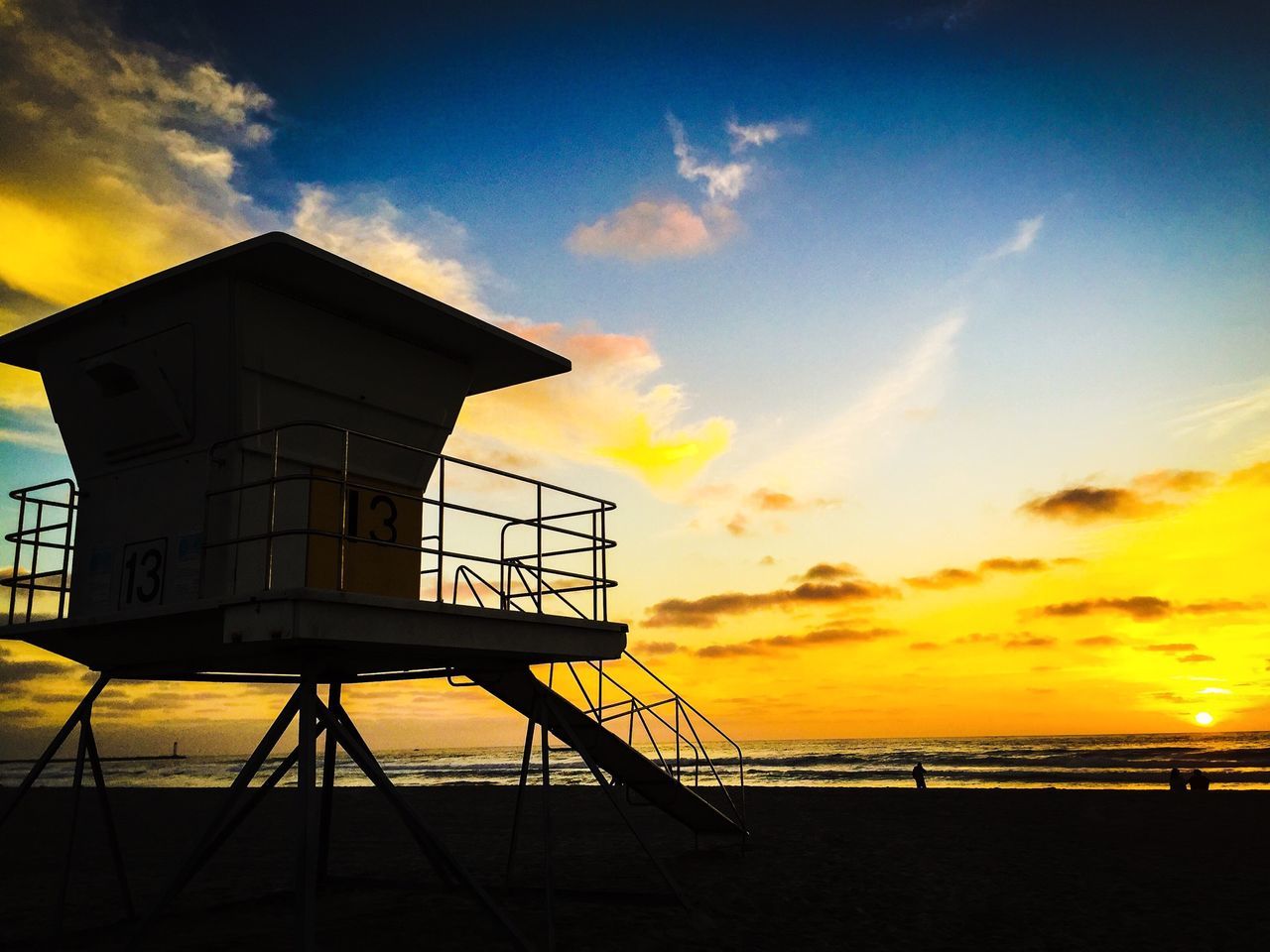 sunset, sea, sky, orange color, horizon over water, water, cloud - sky, built structure, beach, architecture, scenics, beauty in nature, tranquility, silhouette, building exterior, cloud, tranquil scene, yellow, nature, idyllic