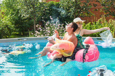 High angle view of woman floating in swimming pool