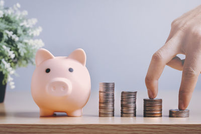 Close-up of hand holding stack of objects on table