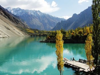 Scenic view of lake by mountains against sky