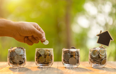 Close-up of hand holding coins on table