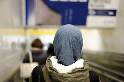 Rear view of person on moving walkway at airport
