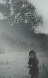 Woman walking on snow covered landscape