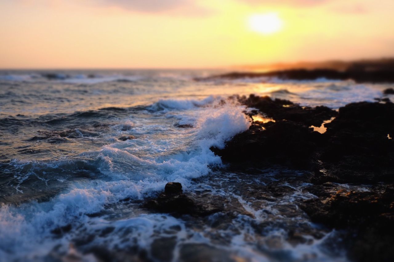 CLOSE-UP OF ROCKS IN SEA AGAINST SKY