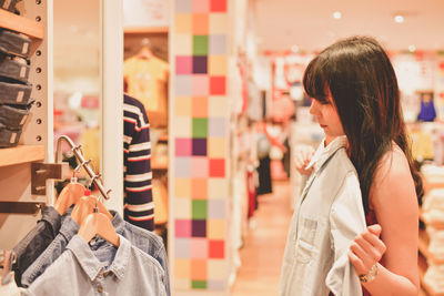 Young woman buying clothes in shopping mall