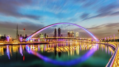 Reflection of illuminated bridge in water at night