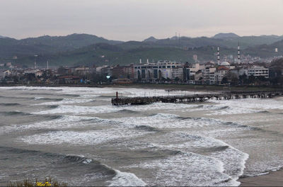 Scenic view of sea by buildings against sky