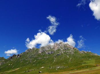 Low angle view of green mountain against sky