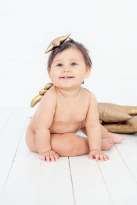 Portrait of cute baby girl sitting at home