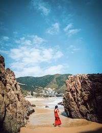 Rear view of people on rock against sky, sea