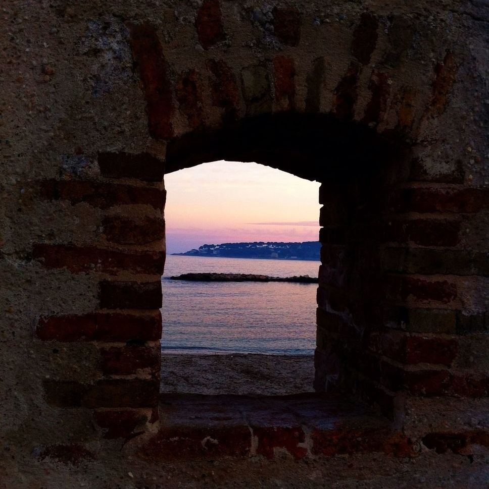 sea, built structure, water, architecture, arch, horizon over water, sky, tranquility, indoors, old, sunset, beach, nature, rock - object, scenics, weathered, stone wall, abandoned, tranquil scene, no people