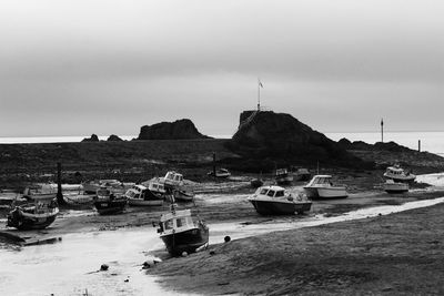 Boats moored on sea against clear sky
