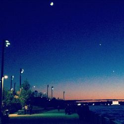 Illuminated street light against clear sky at night