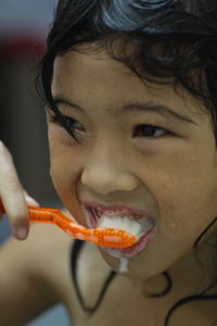 Close-up portrait of girl brushing teeth