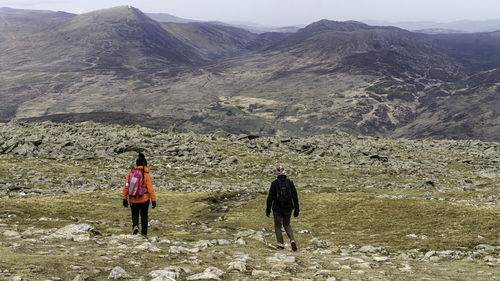 Rear view of men walking on mountain